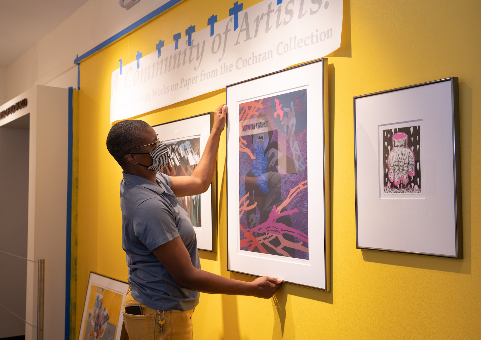 Jerushia Graham installing art exhibit at the paper museum