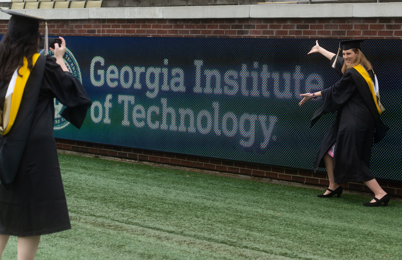 master's student next to the Georgia Tech sign inside the stadium