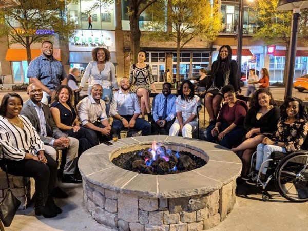 blacks in business group around a fire pit