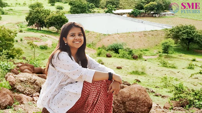 Maithili Appalwar in front of Indian countryside farmland