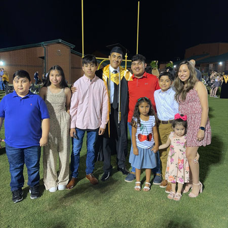 Mario Lopez in graduation regalia with family