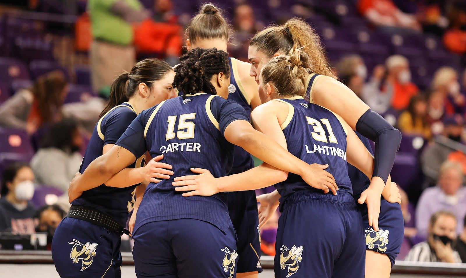 Women's basketball team in a huddle. 