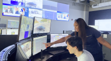 Shireka Graham looks on as a student assistant monitors cameras inside the GTPD Emergency Communications and Operations Center.