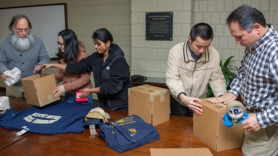 John Bartholdi, director of Global Research in the Supply Chain &amp; Logistics Institute, and students load packages for the Great International Package Race. 