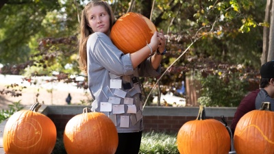 A student holds onto a pumpkin in preparation for the annual School of Physics Pumpkin Drop in 2018