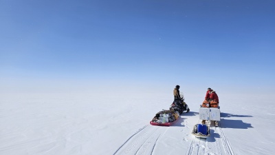 The team snowmobiling to a remote field site.