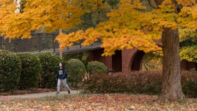 Student Walking on Campus Amid Fall Foliage