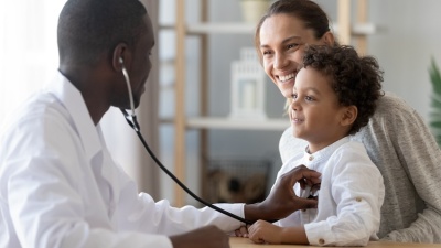 A pediatrician listens to a young patient's heartbeat with a stethoscope