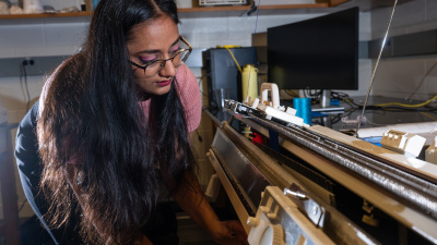Former Matsumoto Group member Krishma Singal operates a knitting machine used to create fabric samples for a previous study. Singal recently graduated from Georgia Tech with her Ph.D. (Photo Credit: Allison Carter)