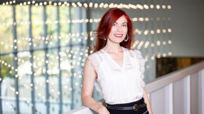Stéphanie Boulard stands next to a banister with a grid of decorative lighting in the background.