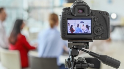 Camera filming people at table