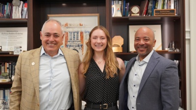 Georgia Tech President Ángel Cabrera, 2026 Truman Scholar Taylor Witte, and Provost Raheem Beyah stand in front of memorabilia-filled bookshelves.