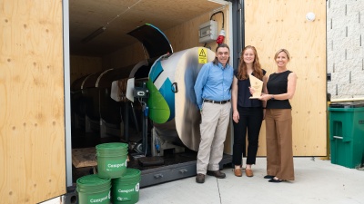 From left to right, Steve Place, campus sustainability program manager; Abby Bower, program and portfolio manager, and Jennifer Chirico, associate vice president of the Office of Sustainability are pictured with Georgia Tech's Sustainability Innovation Award in front of the campus's in-vessel composter.