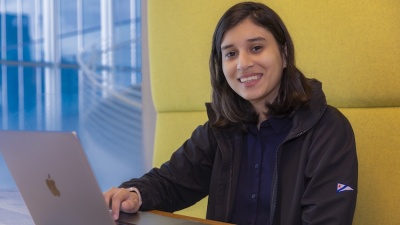 Umme Ammar sits in a booth with laptop in front of her