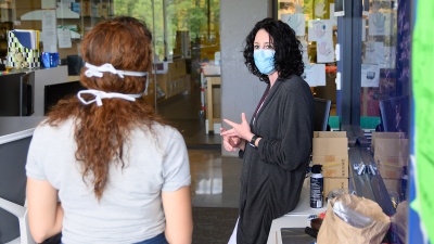 Researchers wear masks and practice distancing in the workspace in the Krone Engineered Biosystems Building