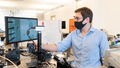 Edgar Garay, a doctoral candidate at Georgia Tech's School of Electrical and Computer Engineering, reviews a set of filaments as part of a  review his microchip design for his startup, Falcomm. (Photo: Matt Hummel)