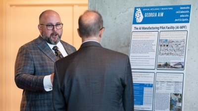 Aaron Stebner (left), associate professor in the George W. Woodruff School of Mechanical Engineering and Georgia AIM co-lead, discusses how the AI Manufacturing Pilot Facility (AI-MPF) advances Georgia AIM goals with Dennis Alvord, the Economic Development Administration’s deputy assistant secretary for economic development and chief operating officer. (PHOTO: Joya Chapman)