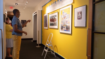 Jerushia Graham (foreground), museum coordinator, and Virginia Howell, museum director, install A Community of Artists: African American Works on Paper From the Cochran Collection. Photo by Joya Chapman.