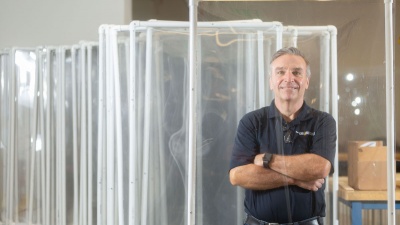Steven Sheffield and his team have been part of Georgia Tech's response to the coronavirus pandemic. He is pictured behind a protective barrier manufactured at Tech. (Photo by Allison Carter.)