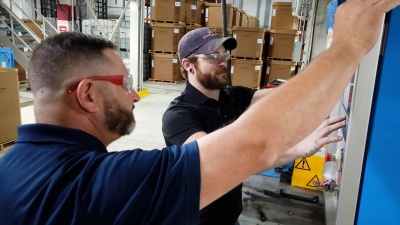 Lead technician, Austin Hicks, taps on a monitoring screen while his co-worker looks on at the manufacturing facility for Silon in Peachtree City, Georgia
