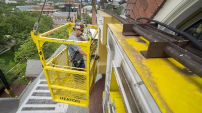 A construction worker replaces the letters on Tech Tower.