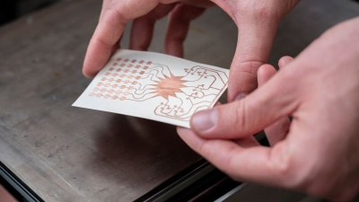 A Georgia Tech ATHENA group member holds an inkjet-printed prototype of a mm-wave harvester. The researchers envision a future where IoT devices will be powered wirelessly over 5G networks. (Photo credit: Christopher Moore, Georgia Tech)