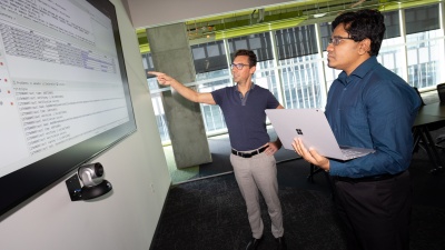Brendan Saltaformaggio, left, and Amit Sikder are working on a $10 million DARPA project to unpack legacy software systems, incorporate updates, and redeploy them in weeks or months rather than years. (Photo: Candler Hobbs)
