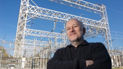 Alex Shapiro, a professor in Georgia Tech's Stewart School of Industrial &amp; Systems Engineering, poses in front of a utility substation. Assistance he provided to Operador Nacional do Sistema Eletrico (ONS) in Brazil helped improve a computer algorithm used to ensure that electricity generation meets the demand. (Georgia Tech Photo: Rob Felt)