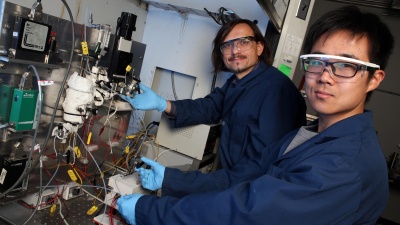 Georgia Tech professor Andrei Fedorov (left) and undergraduate research assistant Yuzhe Peng are shown with the laboratory-scale hydrogen reforming system that produces the green fuel at relatively low temperature in a process that can be scaled up or down to meet specific needs. (Credit: Candler Hobbs, Georgia Tech)