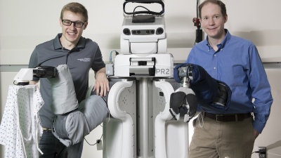 Left to right: Zackory Erickson, a PR2 robot, and Charlie Kemp