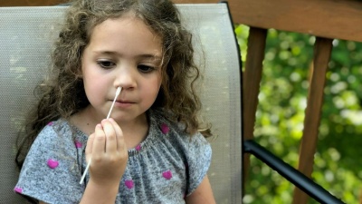 A child swabs their nose for Covid-19 testing.