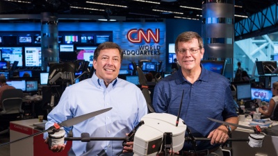 The Georgia Tech Research Institute (GTRI) and CNN have been working together to study the issues affecting the use of unmanned aerial vehicles for newsgathering. Shown in CNN’s World Headquarters are (left) Greg Agvent, senior director of news operations for CNN, and Cliff Eckert, a GTRI senior research associate who’s working on the project. They are shown with an AirRobot AR 180, one of the devices that may be suitable for newsgathering. (Credit: Rob Felt, Georgia Tech)