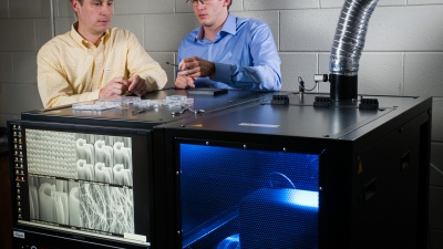 Georgia Tech researchers Jud Ready (left) and Graham Sanborn pose with equipment used to grow carbon nanotubes at the Georgia Tech Research Institute (GTRI) in Atlanta. The nanotubes are being tested for potential use in future electrically-powered ion propulsion systems. (Georgia Tech Photo: Rob Felt)