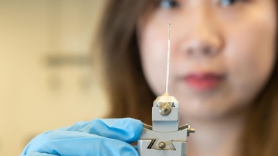 Georgia Tech graduate research assistant Xuetian Ma holds a reaction vessel similar to those used in the research on nanoscale crystalline growth. The vessels were made of a high-strength quartz tube about a millimeter in diameter and about two inches long. (Credit: Allison Carter, Georgia Tech)