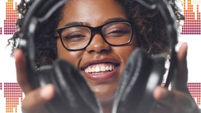 Nylah Julmice offering headphones to listen to a code-composed song.