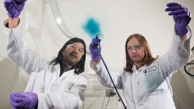 Georgia Tech researchers Eric Shen and Anna Osterholm demonstrate how films of electrochromic polymers can be applied to large surfaces. (Credit: Rob Felt)