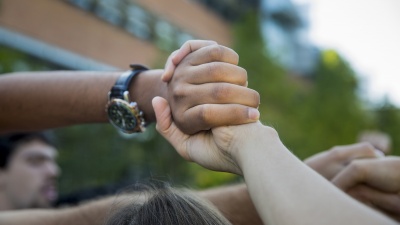 Hands interwoven outside Clough Commons