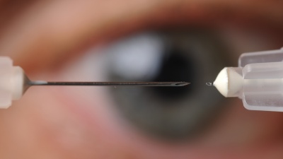 A microneedle used to inject glaucoma medications into the eye is shown next to a conventional hypodermic needle. (Photo credit: Gary Meek).