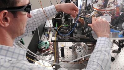 Researcher Kenton Brown adjusts optical components in an experimental setup within GTRI’s Quantum Information Systems Branch. (Credit: Gary Meek)