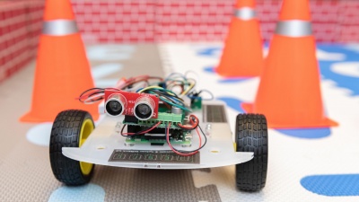 A robotic car controlled by an ultra-low power hybrid chip is shown in an arena to demonstrate its ability to learn and collaborate with another robot. (Photo: Allison Carter, Georgia Tech)