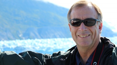 Georgia Tech Teasley Professor Mark Hay is shown with a background of glaciers in Alaska. Hay has spent his career understanding what's killing the world's coral reefs. (Credit: Candace Klein)
