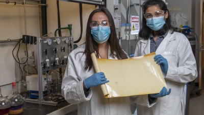 Georgia Tech graduate research assistants Kirstie Thompson and Ronita Mathias with a sample of a new membrane material that could reduce carbon emissions and energy intensity associated with refining crude oil. (Credit: Christopher Moore, Georgia Tech)