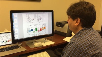 Georgia Tech Professor Howard Weiss reviews data about bacteria found on aircraft studied by a research team that sampled tray tables, seat belt buckles and the handles of lavatory doors. (Credit: John Toon, Georgia Tech)

 