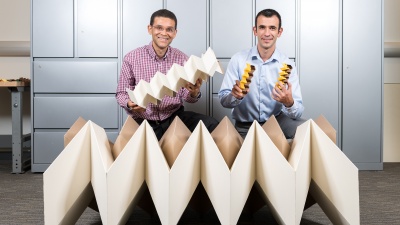Researchers Glaucio Paulino (left) and Evgueni Filipov with three origami structures showing the size flexibility of the "zippered tube" system. Filipov is from University of Illinois at Urbana-Champaign; Paulino is from the Georgia Institute of Technology. (Credit: Rob Felt, Georgia Tech) 