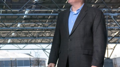 Norman “Finn” Findley, CEO of the startup Quest Renewables, stands beneath his company’s QuadPod Solar Canopy system. Solar canopies are high ground-clearance structures designed for solar panels, but they also function as carports by providing shade for vehicles parked beneath them.