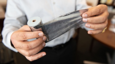 Rampi Ramprasad, a professor in the School of Materials Science and Engineering, holds an aluminum-based capacitor. (Credit: Allison Carter)