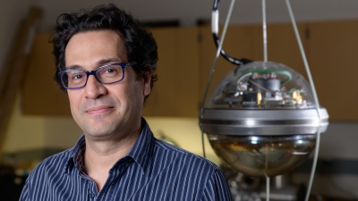 Image shows Georgia Tech Associate Professor Ignacio Taboada with a digital optical module of the kind used in the IceCube Neutrino Observatory. The observatory has 5,000 of the modules suspended in clear ice to detect blue light indicating passage of a neutrino.(Credit: Rob Felt, Georgia Tech)