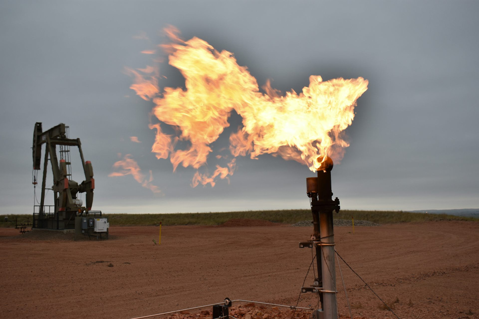 A flare burns natural gas at an oil well on Aug. 26, 2021, in Watford City, N.D. 