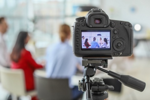 Camera filming people at table