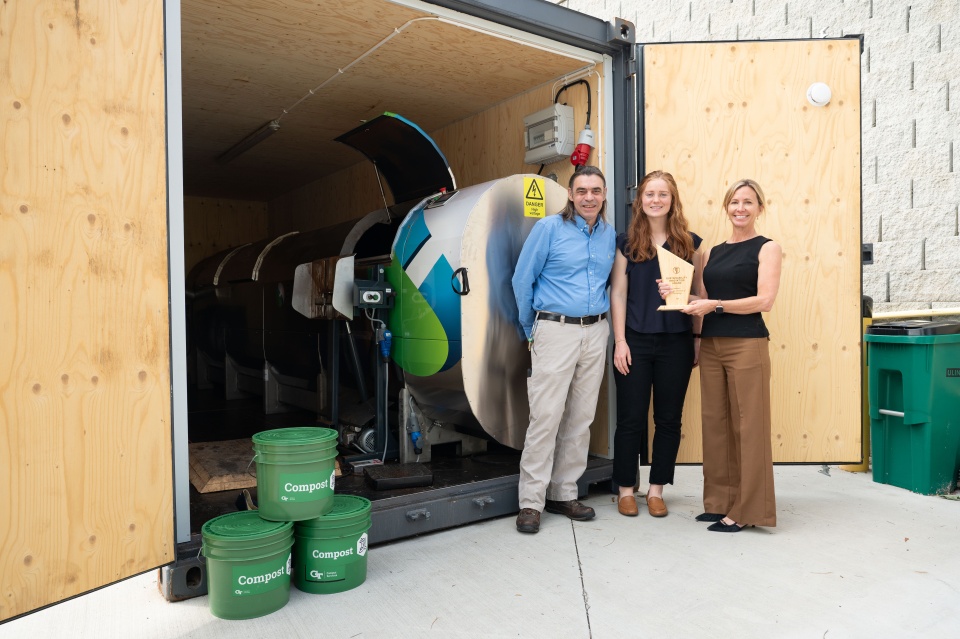 From left to right, Steve Place, campus sustainability program manager; Abby Bower, program and portfolio manager, and Jennifer Chirico, associate vice president of the Office of Sustainability are pictured with Georgia Tech's Sustainability Innovation Award in front of the campus's in-vessel composter.